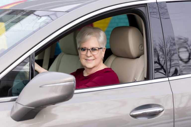 A woman driving a car in low vision glasses