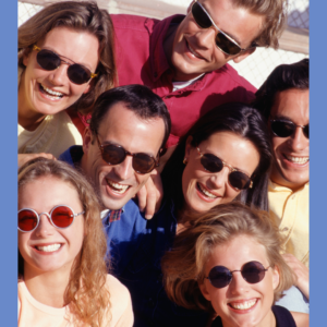 An overhead view of seven people wearing sunglasses and smiling
